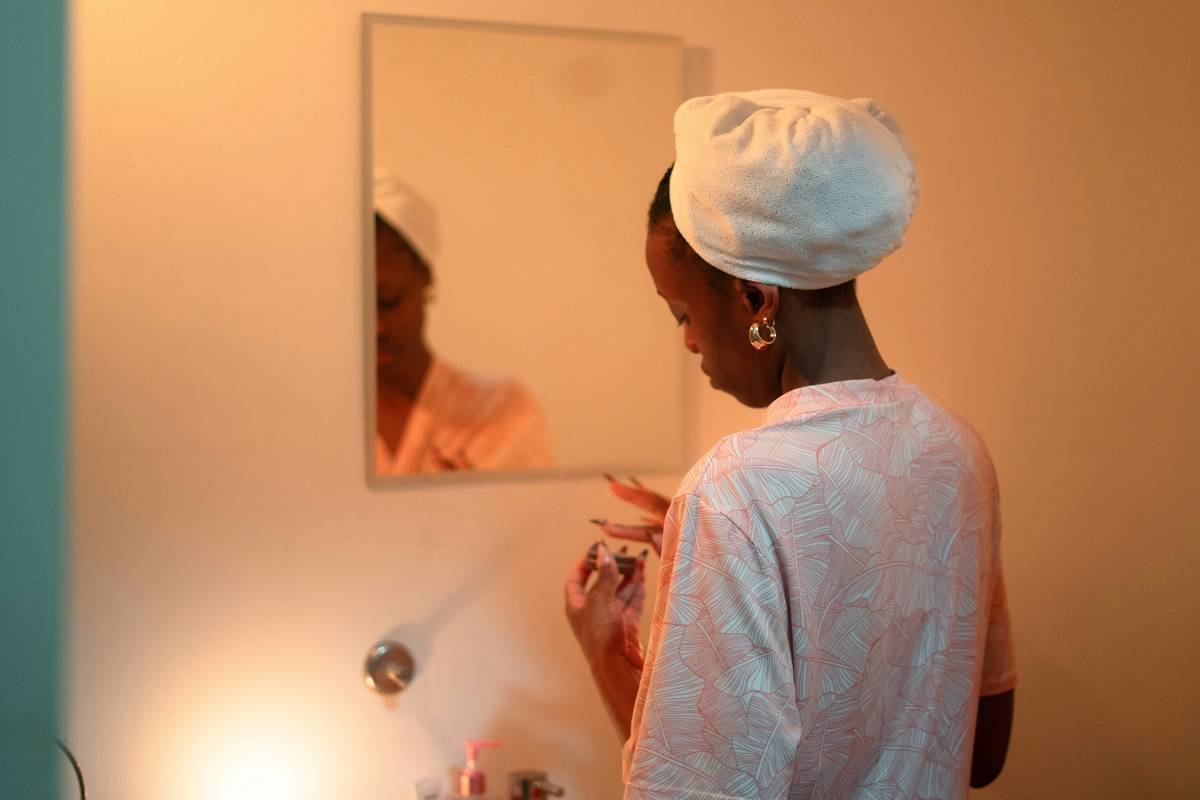 Model using makeup stencil for bold beauty application with symmetrical eyeliner