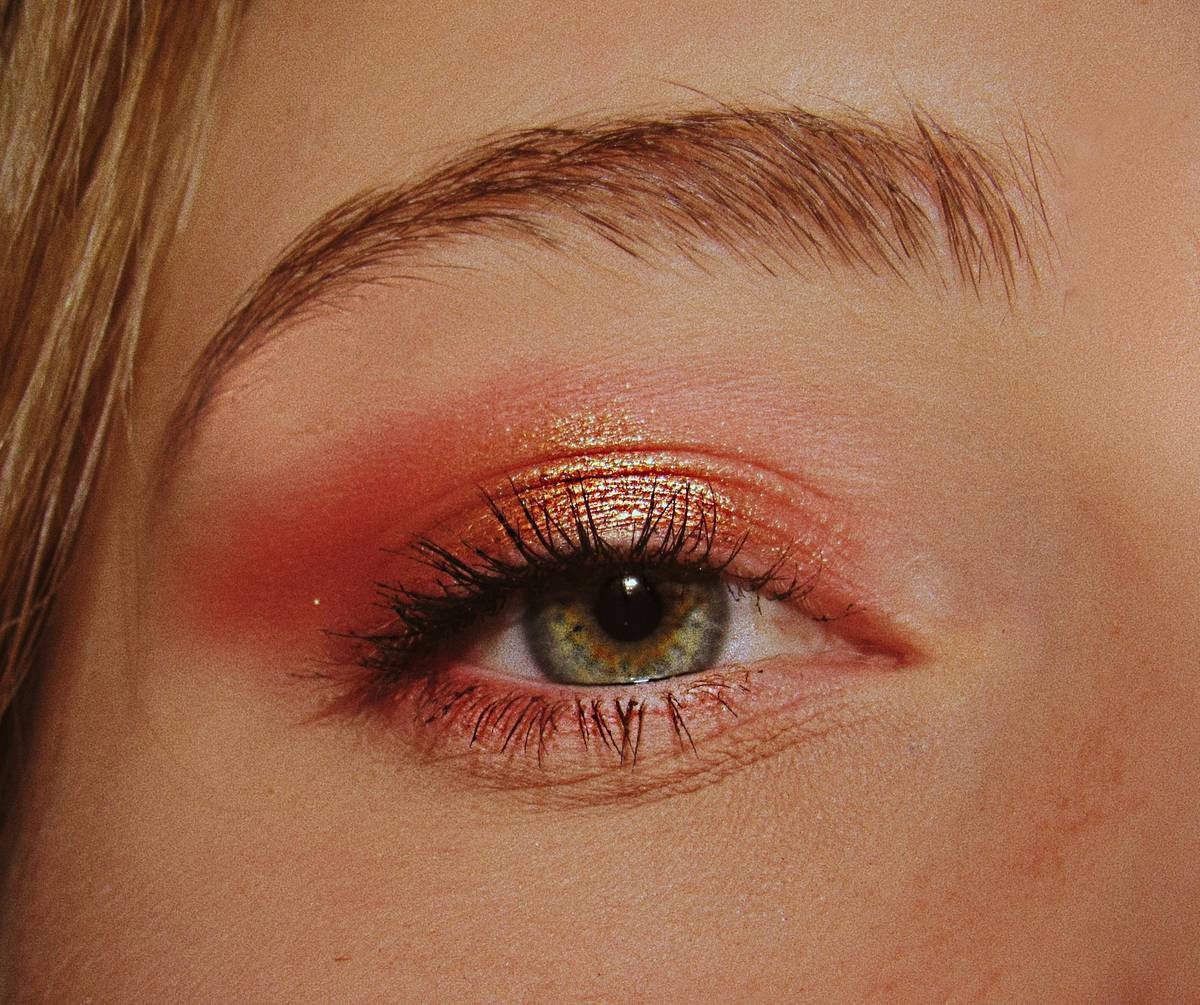 Artist using artistic makeup techniques with silicone stencil on model's cheekbone